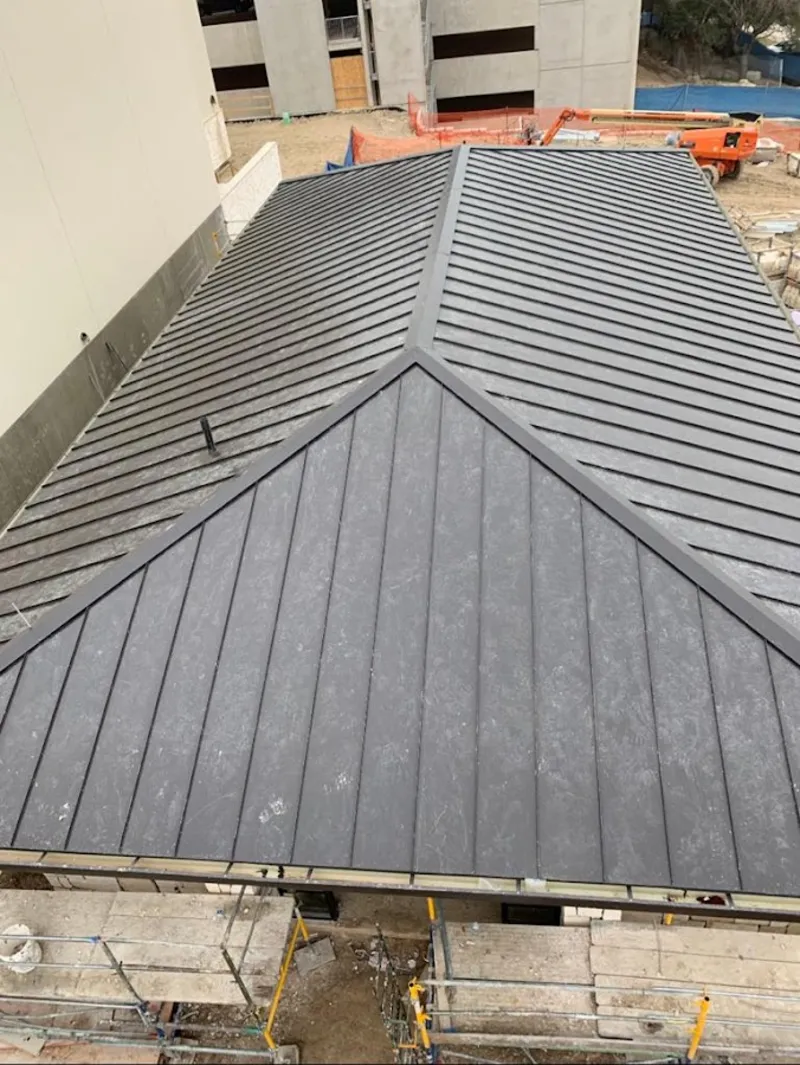 Commercial metal roof construction with crane equipment in Walker